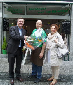 Mit einem großen Blumenstrauß gratulieren Oberbürgermeister Claus Kaminsky und HMG-Mitarbeiterin Hülya Senel Betreiber Stefan Fleck zur Geschäftseröffnung. Mit einem großen Blumenstrauß gratulieren Oberbürgermeister Claus Kaminsky und HMG-Mitarbeiterin Hülya Senel Betreiber Stefan Fleck zur Geschäftseröffnung.