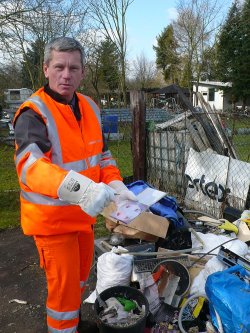 Stadtrat Andreas Kowol hatte sich eigens Arbeitsanzug und Handschuhe angezogen, um dem Verursacher für diese wilde Müllablagerung in Großauheim auf die Spur zu kommen. 