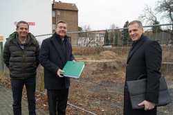 In Anwesenheit von Abu Taleb, dem ehemaligen Grundstückseigentümer (links), übergibt OB Claus Kaminsky die Baugenehmigung für das Wohnbauprojekt an den neuen Grundstückseigentümer Nenad Crnjak von der Procon Projektgesellschaft mbH. 